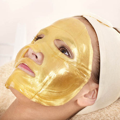 Young womanl with gold facial mask.